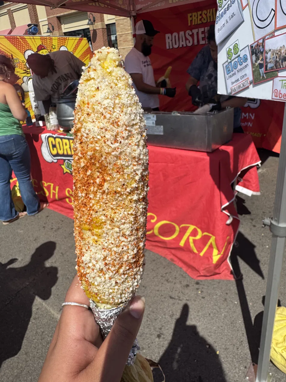 Loaded Mexican street corn (elote) with cotija and chili at the Corn Hole booth at a Minnesota festival.